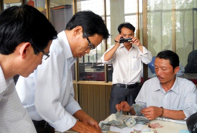 Tiểu thương mới đổi được 17 triệu đồng tiền cháy Cán bộ Ngân hàng Nhà nước kiểm tra số tiền bị cháy của tiểu thương Lương Hồng Thắng
