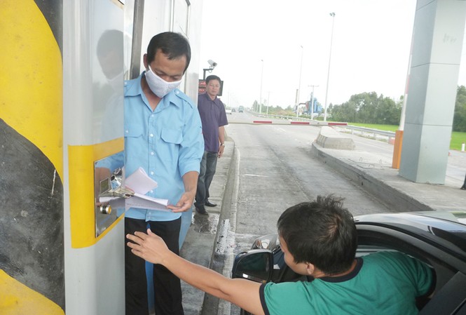Lưu lượng xe giảm 30% Lái xe bấm vào máy để nhận thẻ tại trạm thu phí Thân Cửu Nghĩa. Ảnh: Đức Thịnh