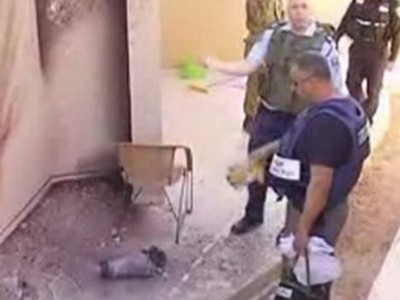 Israel Cảnh sát Israel xem xét sân sau căn nhà bị pháo kích ở thành phố Sderot. Ảnh: Reuters