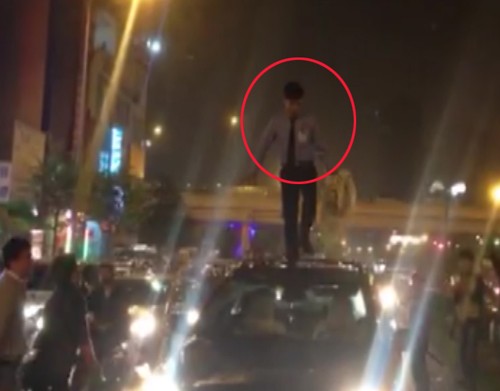 Thanh niên ngáo đá quậy tưng bừng trên nóc ôtô Nam thanh niên đứng trên nóc ôtô nhảy nhót. Ảnh cắt từ clip