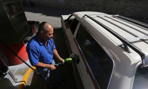 Xăng rẻ như nước, đi 6 vòng Venezuela chỉ tốn 1 USD Henry Duran, một người dân Venezuela đang đổ đầy xăng cho chiếc Ford LTD Ranger sản xuất năm 1978 tại Caracas, Venezuela. Ảnh: AP
