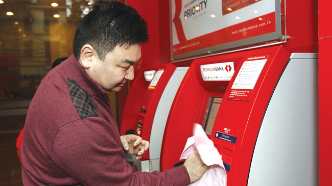 Nghỉ lễ, lo chống “cháy” tiền ATM Ngân hàng lo bảo dưỡng máy ATM. Ảnh: Như Ý.