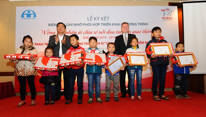 Giúp trẻ mồ côi vì tai nạn giao thông được đến trường Bộ trưởng Đinh La Thăng (trái, hàng sau) cùng các cháu bé có người thân bị mất vì tai nạn giao thông.