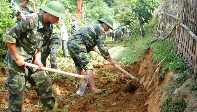 Cống hiến và trưởng thành ĐVTN Bộ đội Biên phòng Nghệ An giúp nhân dân địa phương làm đường giao thông ở bản Cò Phạt thuộc xã Môn Sơn, huyện Con Cuông.
