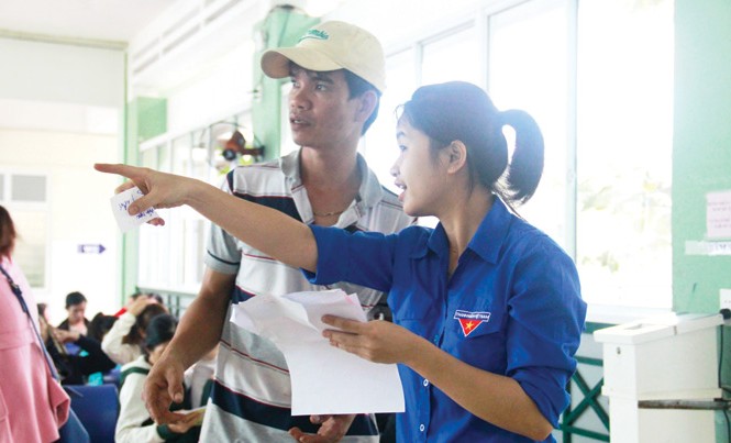 Tiếp sức bệnh nhân Tình nguyện viên hướng dẫn lối đi, cách làm thủ tục cho người nhà bệnh nhân. Ảnh: Thanh Trần.