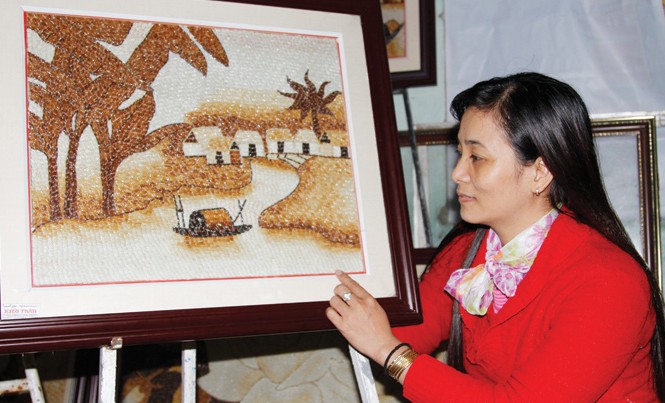 Hồn quê trong tranh gạo của Kiều Kiều và những bức tranh gạo của mình. Ảnh: H.T.