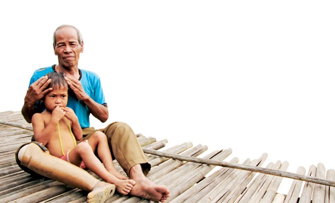 Tình rừng và người của 'lão gàn' Hồ Mơ Ông Mơ đang ôm cháu Hồ Dừa (4 tuổi, mồ côi cha mẹ) vào lòng nâng niu, vỗ về. Ảnh: H.T.