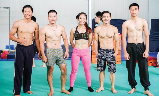 “Hot boy” thể dục dụng cụ Việt Nam: Sống trọn với đam mê Phạm Phước Hưng (thứ 2 bên phải) và các HLV làm việc tại phòng tập TDDC của anh. Ảnh: TĐ.