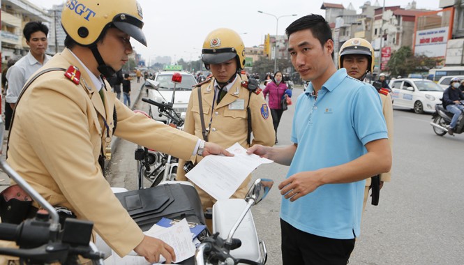 Hà Nội: Lập tổ cơ động “trị” lái xe vi phạm Tổ cơ động mạnh, CSGT Công an thành phố Hà Nội lập biên bản phạt lái xe taxi dừng đỗ sai. Ảnh: Hồng Vĩnh