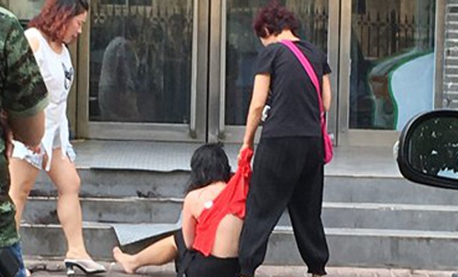Dịch vụ đánh ghen thuê đắt khách Một phụ nữ bị cáo buộc ngoại tình bị lột áo, bị đánh đập trên đường phố Trịnh Châu, tỉnh Hà Nam ngày 12/7. Ảnh: CFP