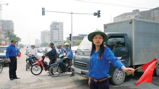 Trao truyền ngọn lửa anh hùng cách mạng Thanh niên tình nguyện quận Hoàng Mai, Hà Nội tham gia hướng dẫn giao thông. Ảnh: Hồng Vĩnh