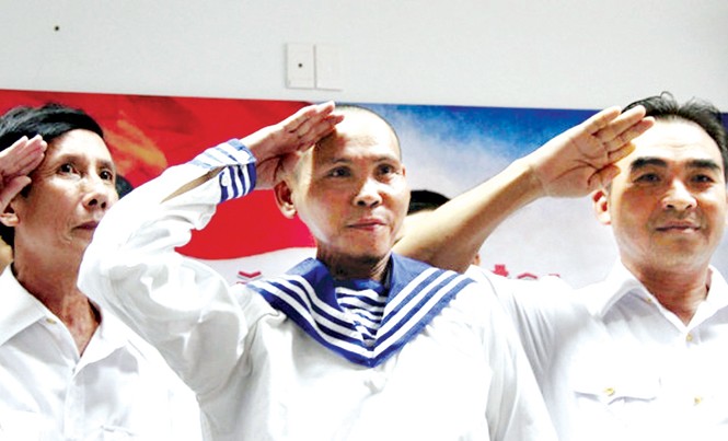 Dũng Gạc Ma đã chào đồng đội... Anh Dũng (giữa) và những cựu binh Gạc Ma đưa tay chào theo điều lệnh