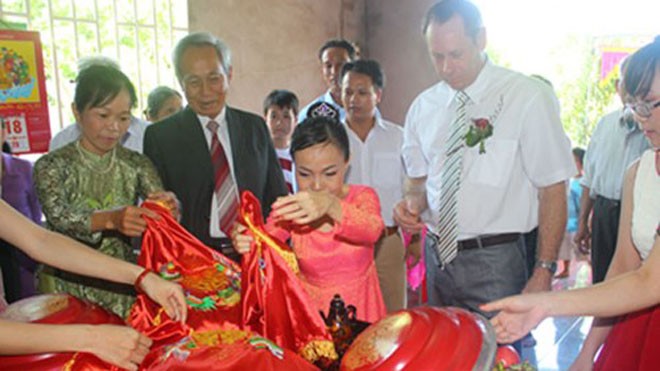 Chuyện tình cô gái Việt tật nguyền với ông chủ tiệm xe hơi Lễ đính hôn của Khánh Xuân (áo dài đỏ) và Freddie Scott (áo trắng) tại nhà
- Ảnh do nhân vật cung cấp