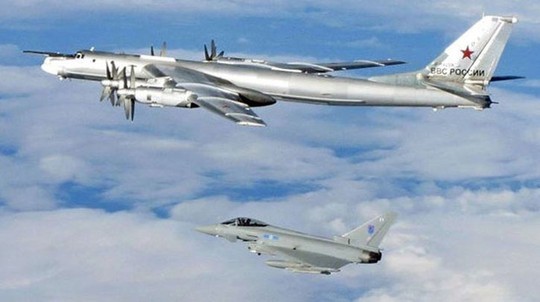 Anh triệu đại sứ Nga sau vụ máy bay ném bom “đi lạc” Một chiếc Tu-95 Bear (phía trên) được chiến đấu cơ Typhoon hộ tống ra khỏi không phận Anh tháng 4-2014. Ảnh: UK Mod