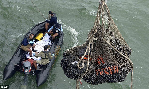 Thân máy bay AirAsia đã vỡ, tập trung tìm đuôi Các túi đựng thi thể hành khách chuyến bay QZ8501 được đưa từ thuyền nhỏ lên tàu hải quân Indonesia KRI Banda Aceh.