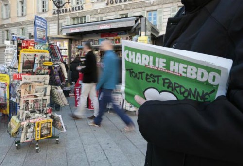Số lượng phát hành Charlie Hebdo lên đến 7 triệu bản Một người cầm số mới nhất của tạp chí Charlie Hebdo. Ảnh: Reuters