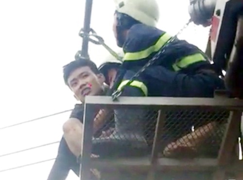Cảnh sát dùng xe thang 'cứu' nam thanh niên đi trên dây điện Thành được cảnh sát đưa xuống bằng xe thang.