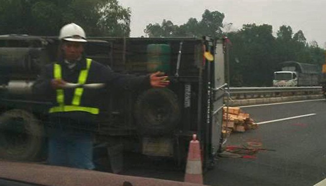 Xe tải chở gỗ nổ lốp lật nhào trên cao tốc Nội Bài – Lào Cai Lực lượng chức năng có mặt tại hiện trường ngay sau khi xảy ra vụ tai nạn điều tiết giao thông. Ảnh: Otofun.