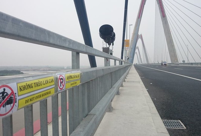 Dán nhiều biển cấm trên cầu Nhật Tân Các công nhân dán các tấm biển trên cầu Nhật Tân.