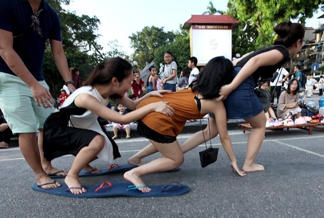 Bật cười với những trò lạ bên Hồ Gươm Để đi đôi dép kỳ cục này không phải dễ, các bạn trẻ liên tục ngã do bước không đều khi chơi trò chơi miễn phí này