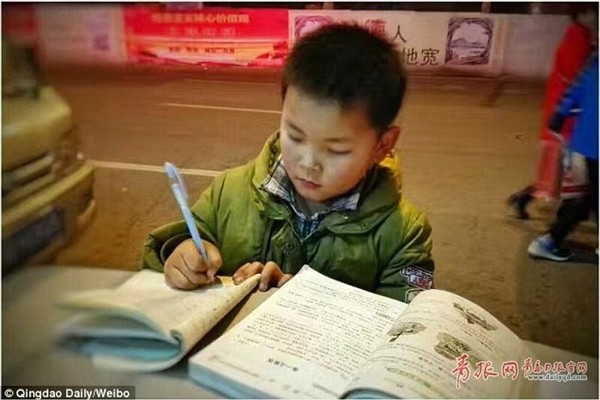 Dân mạng thổn thức với cậu bé học bài trên nắp thùng rác Dân mạng thổn thức với cậu bé học bài trên nắp thùng rác