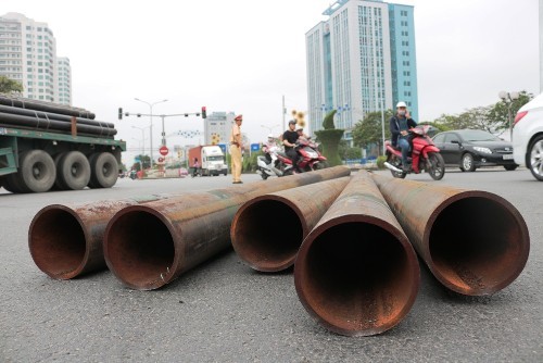 10 ống thép nặng hàng tấn lao từ xe đầu kéo xuống đường 10 cây thép nặng hàng tấn nằm dưới đường. Ảnh: Giang Chinh.