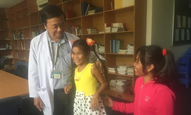 “Cô bé mai rùa” tươi vui xuất viện sau phẫu thuật Bác sĩ Đào Trung Hiếu chia sẻ niềm vui với mẹ con bé Thắm. Ảnh: Quốc Ngọc