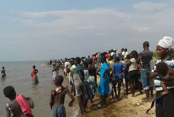 Chìm tàu ở Uganda, 30 người chết và mất tích Người dân tập trung quanh hồ Albert thể theo dõi công tác cứu hộ tàu chở đội bóng bị lật. Ảnh: Twitter