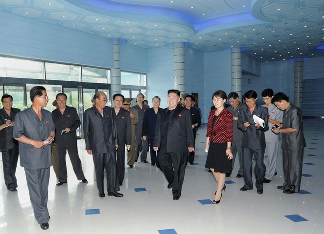 Vợ chồng ông Kim Jong Un trao đổi cùng các quan chức khác