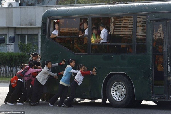 Học sinh đang giúp đẩy chiếc xe bus tại thủ đô Bình Nhưỡng