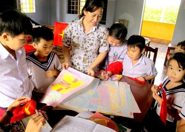 Cô giáo Nhung bên cạnh các em học sinh