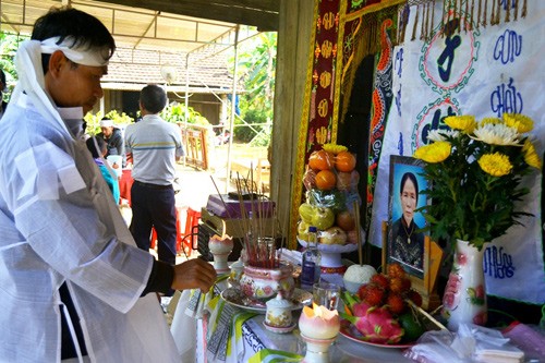 Con trai bà Tri bên bàn thờ mẹ. Ảnh: Nguyễn Dương