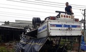 Xe tải ủi bay hàng rào, lật ngửa trước nhà dân