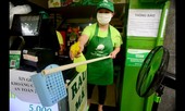 Nhân viên quán nước dùng gậy tự chế đưa tiền cho khách trong mùa dịch