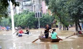 Lũ lụt dâng cao, người dân chèo thuyền đi lại trên phố