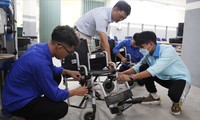 Những “thợ áo xanh” của Đoàn Trường Cao đẳng Nghề Đà Nẵng đang sửa chữa chiếc xe lăn hư hỏng Ảnh: Giang Thanh 