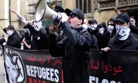 Alex Davies phát biểu tại một cuộc biểu tình National Action năm 2016 ở York, trước biểu ngữ ghi “Người tị nạn không được chào đón: Hitler đã đúng” 