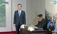 Ông Kim Jong-un ngồi viết lưu bút sáng 27/4 tại Nhà Hòa Bình. Ảnh: KBS