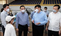 Bộ trưởng Nguyễn Thanh Long trò chuyện với người tiêm chủng vaccine tại điểm tiêm chủng trên phố Trịnh Hoài Đức, TP Hà Nội. Ảnh: BYT
