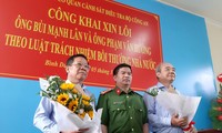 Thượng tá Đặng Trọng Cường tặng hoa cho ông Lân (trái) và Hướng (phải) tại buổi công khai xin lỗi. Ảnh: Tân Châu