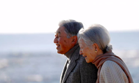 Nhà Vua Akihito và Hoàng hậu Michiko trong một cuộc đi dạo trên bãi biển. (Ảnh: Kyodo)