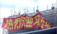 Các công nhân đang treo biểu ngữ chào mừng Chủ tịch Trung Quốc Tập Cận Bình. (Ảnh: Reuters)