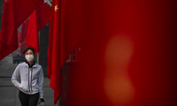 Một phụ nữ đeo khẩu trang khi đi bộ ở Bắc Kinh dịp Tết âm lịch vừa qua. (Ảnh: CNN)
