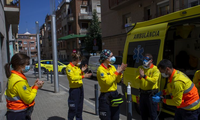 Các nhân viên y tế Tây Ban Nha khử trùng tay sau khi vận chuyển một bệnh nhân hôm 6/4. (Ảnh: AP)