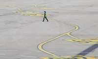 Một nhân viên đi trên đường băng của sân bay quốc tế ở Bắc Kinh ngày 9/3. (Ảnh: Reuters)