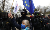 Một phụ nữ vẫy cờ EU trước đại sứ quán Nga ở CH Séc. (Ảnh: AP)