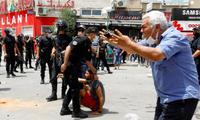 Một người đàn ông phản ứng khi cảnh sát bắt một người biểu tình ở Tunis ngày 25/7. (Ảnh: Reuters)