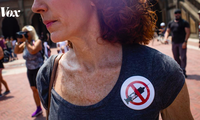 Một phụ nữ Mỹ mặc áo có biểu tượng phản đối tiêm vắc-xin. (Ảnh: Vox)