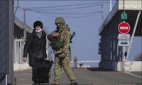 Một phụ nữ đi qua trạm kiểm soát ở miền đông Ukraine ngày 21/2. (Ảnh: AP)