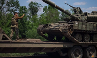 Một lính Ukraine hướng dẫn xe tăng lên xe tải ở vùng Donest ngày 8/6. (Ảnh: Reuters)